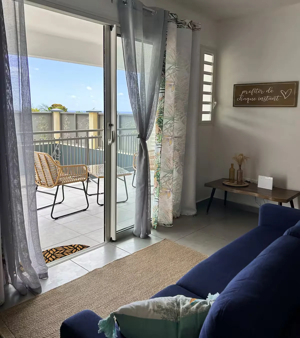 Séjour Chandelle et sa porte vitrée ouverte vers l’extérieur