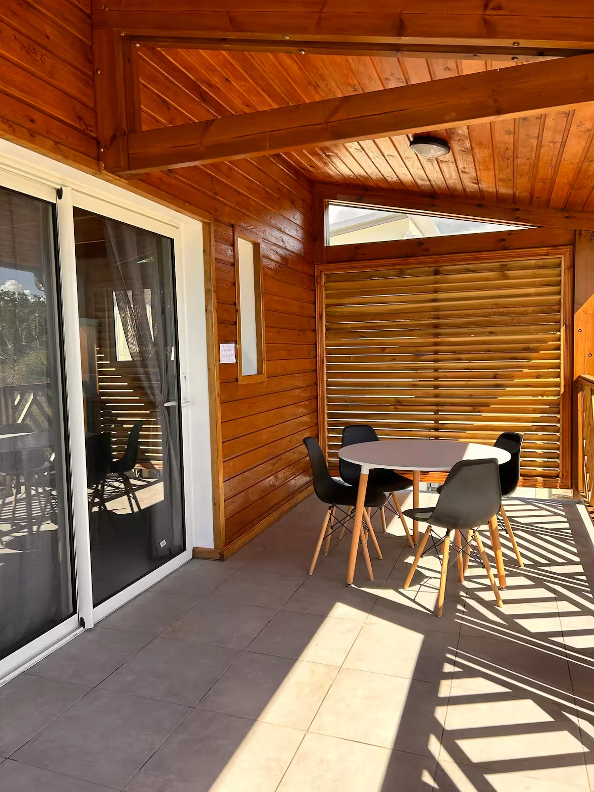 Terrasse couverte Émeraude avec table, chaises et garde-corps en bois